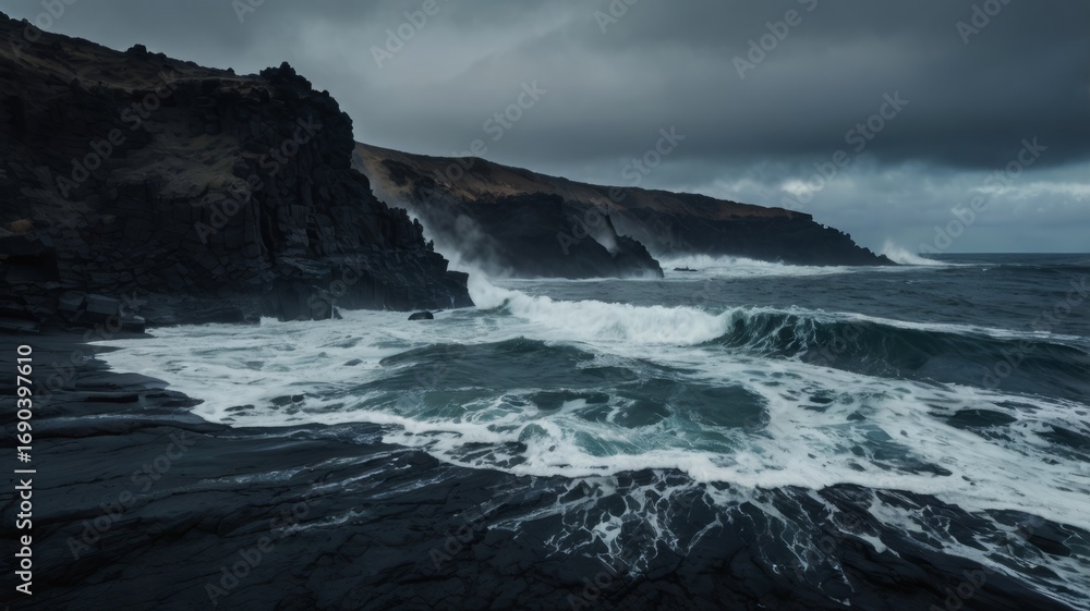 Fototapeta premium Jagged black volcanic coast with crashing waves, moody ocean atmosphere