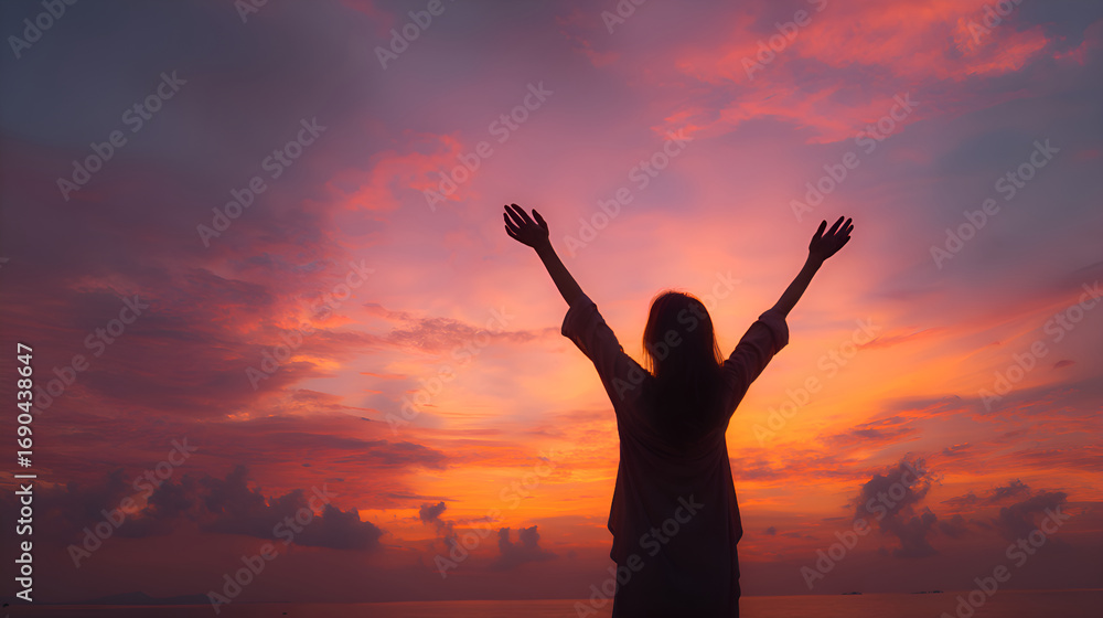 Fototapeta premium Woman raising hands at sunset, feeling freedom and happiness