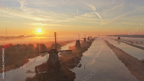 Sunrise drone video of Kinderdijk iconic windmills with soft fog, Holland