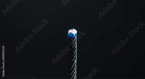 Close-up of a frayed steel cable with a bright spark at the end against a dark background.