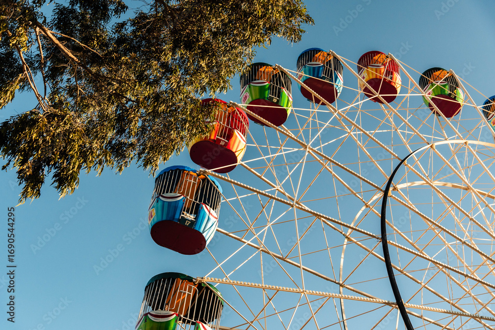 Colourful Ferris Wheel Ride Against a Blue Sky in the Afternoon Sun