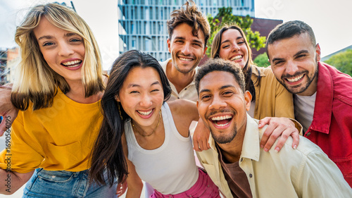 Happy multiracial friends having fun on city street - Group of young people smiling at camera outside - Friendship concept with guys and girls walking in downtown road