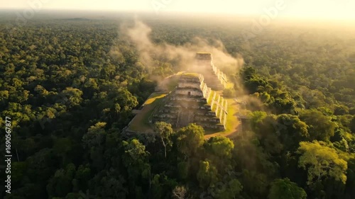 Aerial drone view of ancient ruins emerging from a lush jungle canopy at sunrise, with mist swirling around the stone structures, highlighting a lost civilization