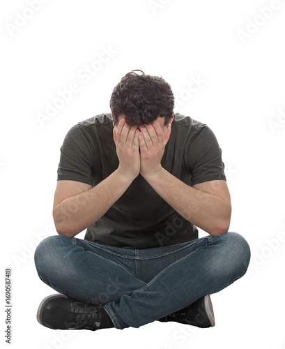 Stressed and depressed man seated on the floor covers face feeling desperate and anxious. Male full length portrait isolated on transparent background