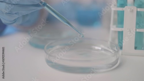Scientist dropping pipette blue liquid laboratory chemical chemistry research medicine concept