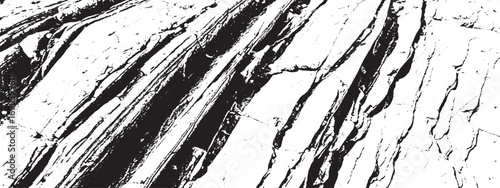Closeup of rough textured rock surface with deep cracks and striations creating natural black and white pattern