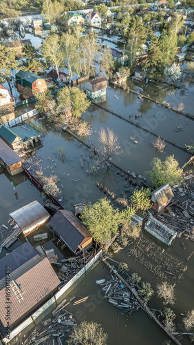 Aerial drone footage showing severe flooding with submerged houses and roads. Wide overhead view of a disaster zone after heavy rainfall, showcasing water damage, extreme weather, and climate-related 