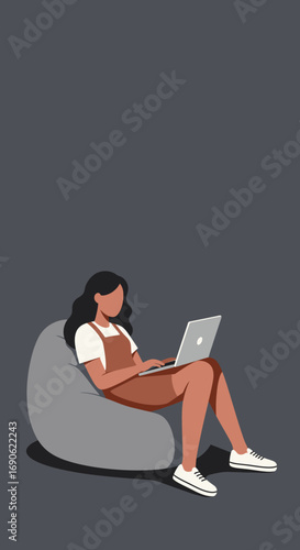Young woman working remotely on her laptop while sitting comfortably on a bean bag. Ideal for concepts of home office, flexible work, and digital lifestyle.