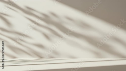 Neutral beige studio background with aesthetic leaf shadows from sunlight, creating a modern podium for product display.