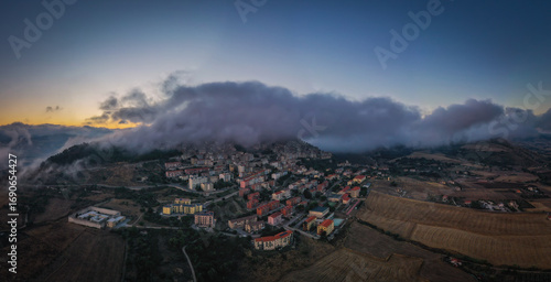 Foto Sunrise view of the rooftops of Gangi with morning fog