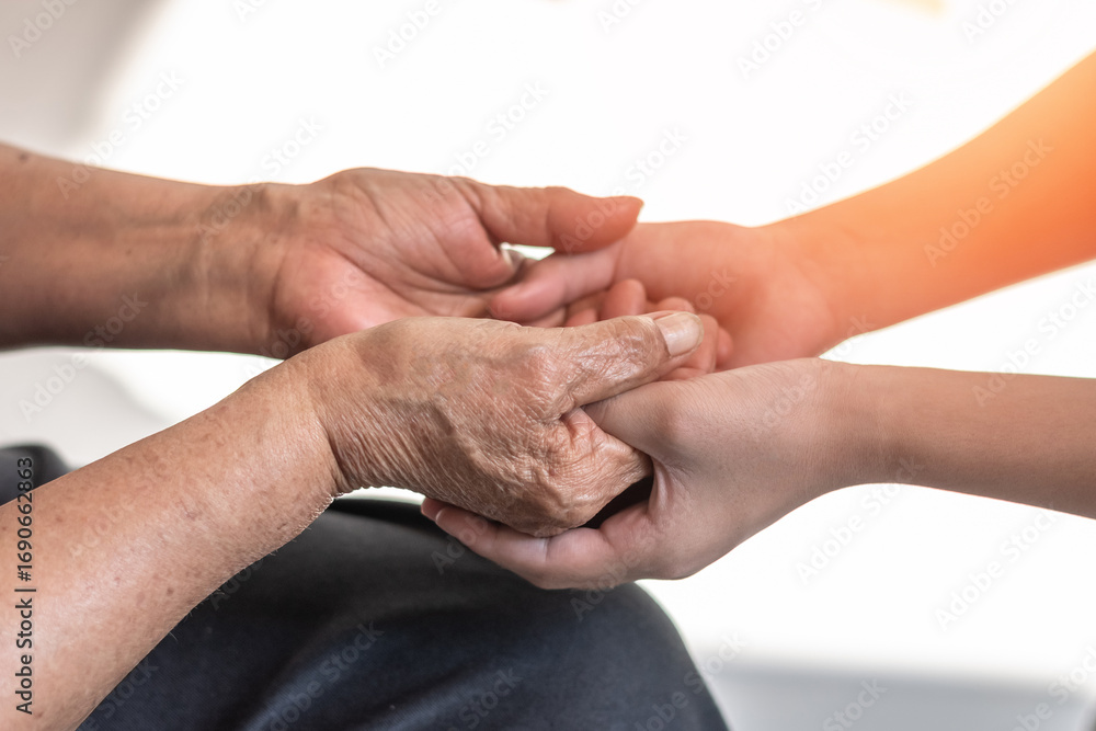 Fototapeta premium Parkinson disease patient, Alzheimer elderly senior, Arthritis person's hand in support of nursing family caregiver care for disability awareness day, National care givers month, aging society concept