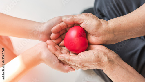 Elderly care with heart in hand of older person, Parkinson disease patient elder senior for family caregiver for disability awareness day, National care givers month, hospice palliative care concept