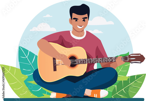 A cheerful young man sits cross-legged outdoors, smiling while playing an acoustic guitar among green leaves.