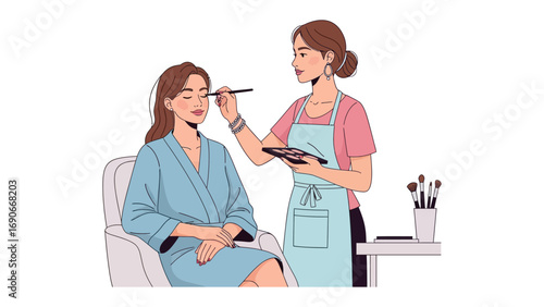 Professional makeup artist applying cosmetics to a seated woman wearing a blue robe in a bright clean studio setting with tools visible