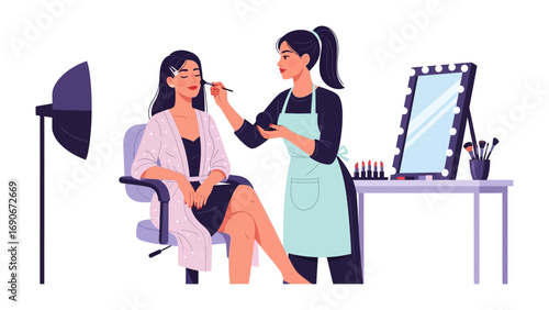 Professional makeup artist applying cosmetics to a seated model in a studio with lighting and a mirror