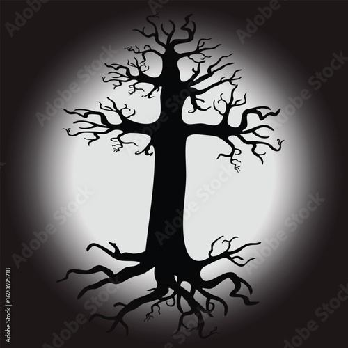 Spooky silhouette of a bare tree with gnarled roots and branches in a spotlight