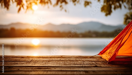 Near a lake in the mountains, a wooden table is set at sunset with a tent in the background, embodying the concept of a summer holiday, leisure, and vacation, and highlighting natural scenic