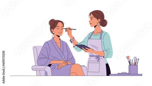 Professional makeup artist applying eyeshadow to a client sitting in a chair wearing a robe in a beauty salon setting