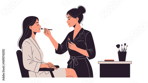 Young woman applying makeup to another woman s face with a brush in a beauty salon or studio setting