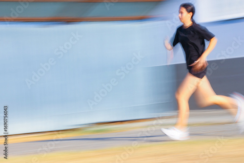  teenager girl running Sity street. Blur.