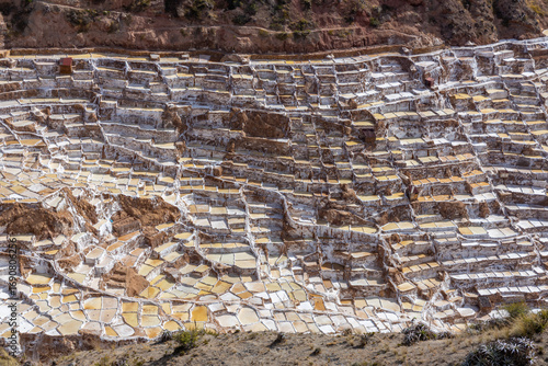 Salineras de Maras in Peru natural salt pools on the mountain terraces tourist attraction and famous sight of Sacred valley of Incas near Cusco. Salt bassins on the mountain slopes in Peru