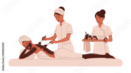 Two women in spa uniforms applying a mud mask to a client lying on a massage table in a serene wellness setting