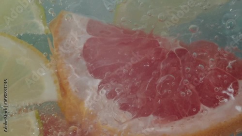Bright slices of grapefruit, lime, lemon, and orange are immersed in sparkling water, creating a vibrant