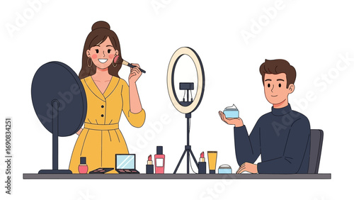 Young woman applying makeup with a brush in front of a large mirror and a man holding a product next to a ring light
