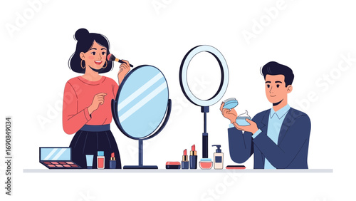 Young woman applying makeup with a brush in front of a mirror while a man holds makeup products near a ring light