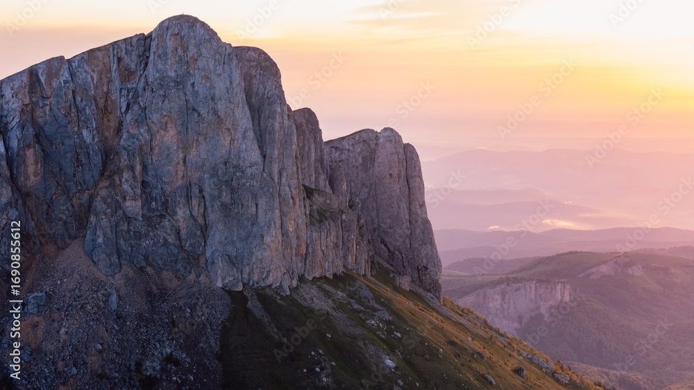 Obraz premium Drone shot of Bolshoy Tkhach rocky dramatic mount in Caucasus with sunset or sunrise tones