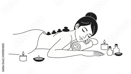 Relaxed woman receiving hot stone massage therapy with candles and essential oils for ultimate wellness and serenity