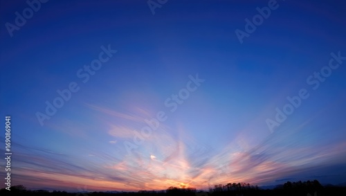 Fototapeta Naklejka Na Ścianę i Meble -  Dramatic sunset sky with sun rays over silhouetted trees