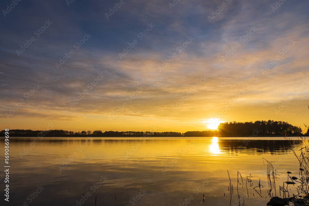 Naklejka premium Sunset Panorama of lake near Alkmaar, Netherlands – Historic landscape with colorful sky