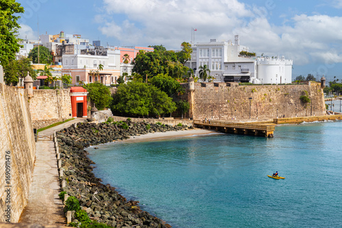 Historic coastal fort and colorful colonial buildings of Old San Juan, Puerto Rico, overlooking the Caribbean Sea with vibrant waterfront scenery.