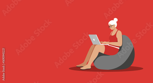 A modern older woman comfortably working or browsing on a laptop from a beanbag chair. Represents remote work, senior tech, and relaxed lifestyle.