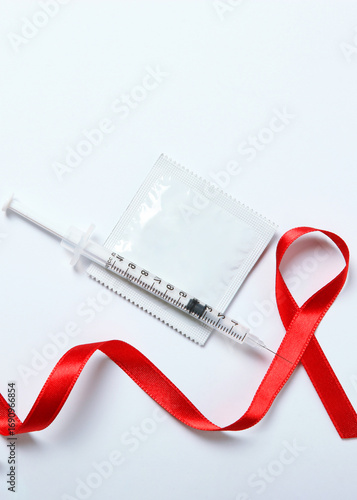Condoms and red ribbon symbolizing AIDS. World AIDS Day. Vertical photo format