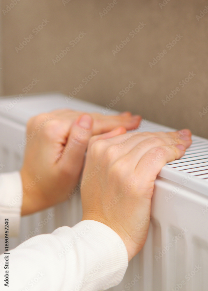custom made wallpaper toronto digitalGirl hands checks the radiator for heat. Vertical photo format
