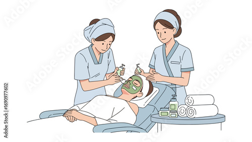 Two women in spa uniforms applying facial treatments and hair care to a client lying down with a towel wrapped around their head
