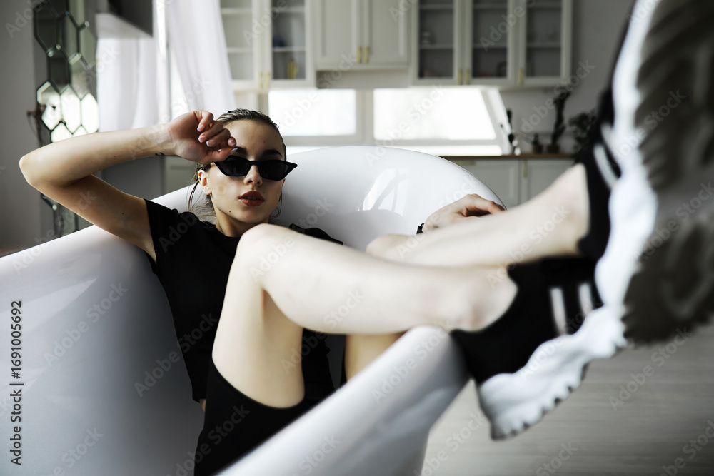 Obraz premium Female student in resting in the room. Young stylish girl posing in the loft. Blonde with glasses.