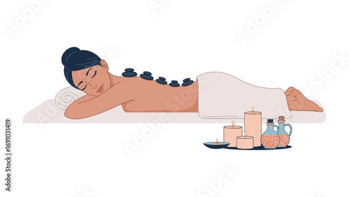 Relaxed woman receiving a soothing hot stone massage therapy treatment at a serene spa with candles and oils