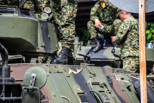 Soldiers boarding armored vehicle, Military climbing onto tank, Armed forces entering armored troop carrier. High quality photo