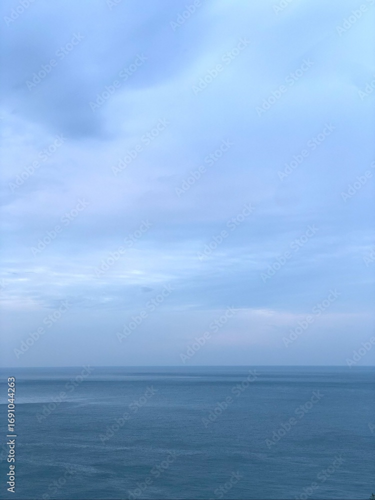 Fototapeta premium Calm seascape with soft blue sky and horizon.