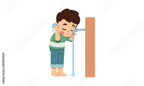 A young boy performing Wudu (ablution) by washing his face at a faucet.