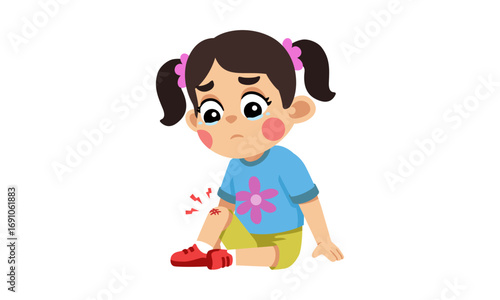 A young girl with brown hair and pigtails is sitting down, looking sad with a scraped knee.