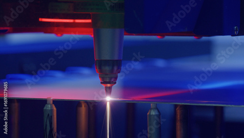 Automated industrial laser precisely cutting a metal sheet in a modern factory, showcasing advanced manufacturing technology and precision engineering