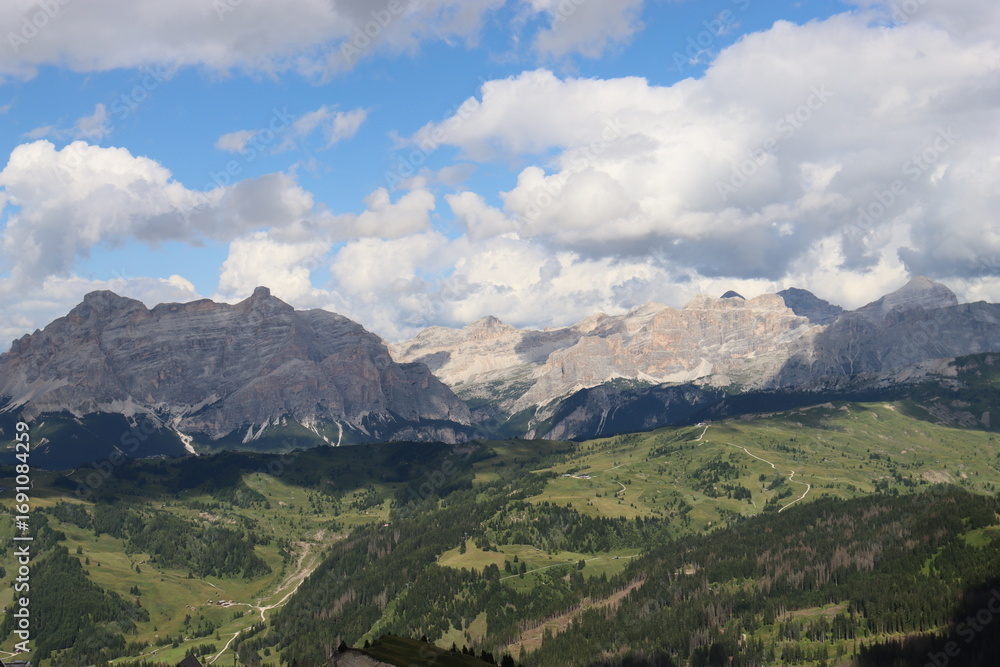 Fototapeta premium Trentino, Italy - July 29, 2025: Stunning Alpine scenery of breathtaking Dolomites rocks mountains in Italian Alps. Marmolada glacier seen in the distance from the slopes of the Porta Vescovo Dolomite