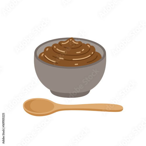 Bowl of miso paste sits next to wooden spoon on white surface, representing traditional Japanese cuisine and culinary ingredient, simple and clean.