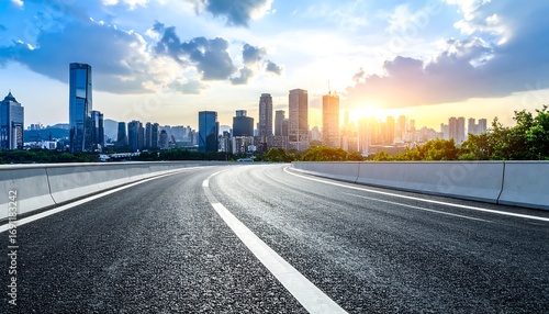 Asphalt road winding through city skyline at sunset