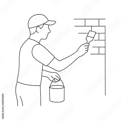 Man painting a brick surface with a brush while holding a bucket  