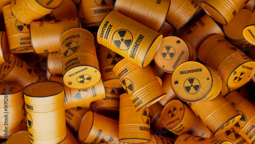Numerous yellow barrels containing radioactive materials are stacked haphazardly, creating a visual representation of potential environmental disaster and the dangers of nuclear waste